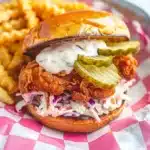Nashville hot chicken sandwich with crispy chicken, creamy slaw, pickles, and crinkle fries