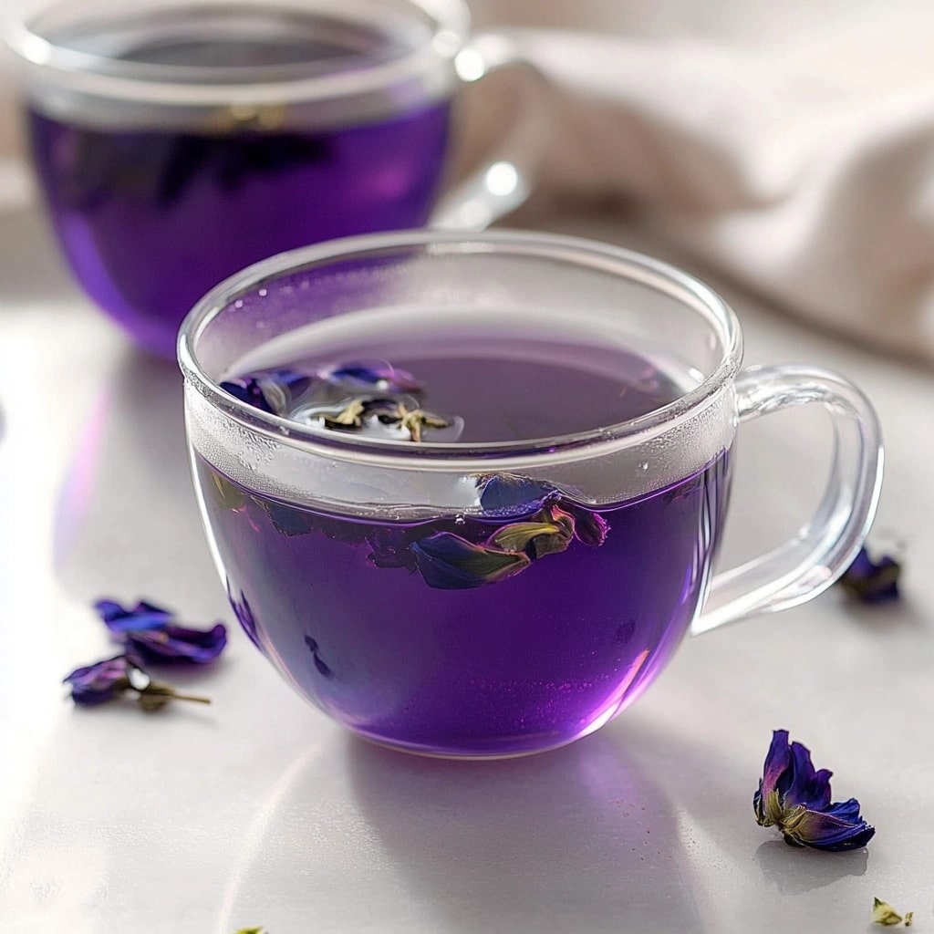 Enjoy a calming brew made from one of the most iconic Brazilian Mounjaro ingredients—whole butterfly pea flowers. Two cups of freshly brewed butterfly pea flower tea with floating petals