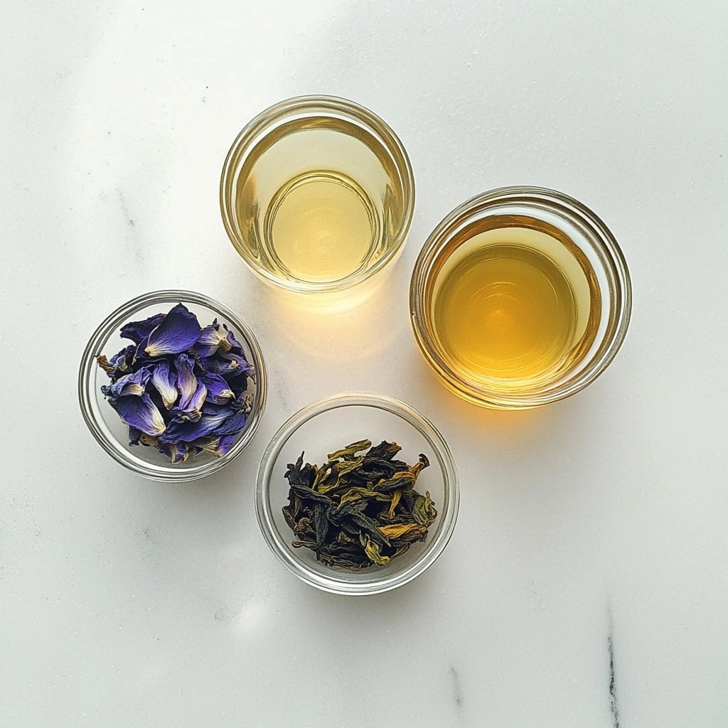 A look at raw butterfly pea flowers and tea blends that form the natural base of the Brazilian Mounjaro drink. Overhead view of butterfly pea flowers, green tea leaves, and brewed herbal infusions