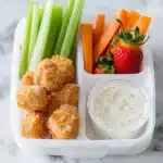 Homemade chicken nugget lunchable with celery, carrots, strawberries, and ranch dressing