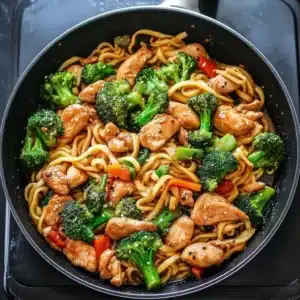 Chicken and broccoli stir fry with noodles in a skillet