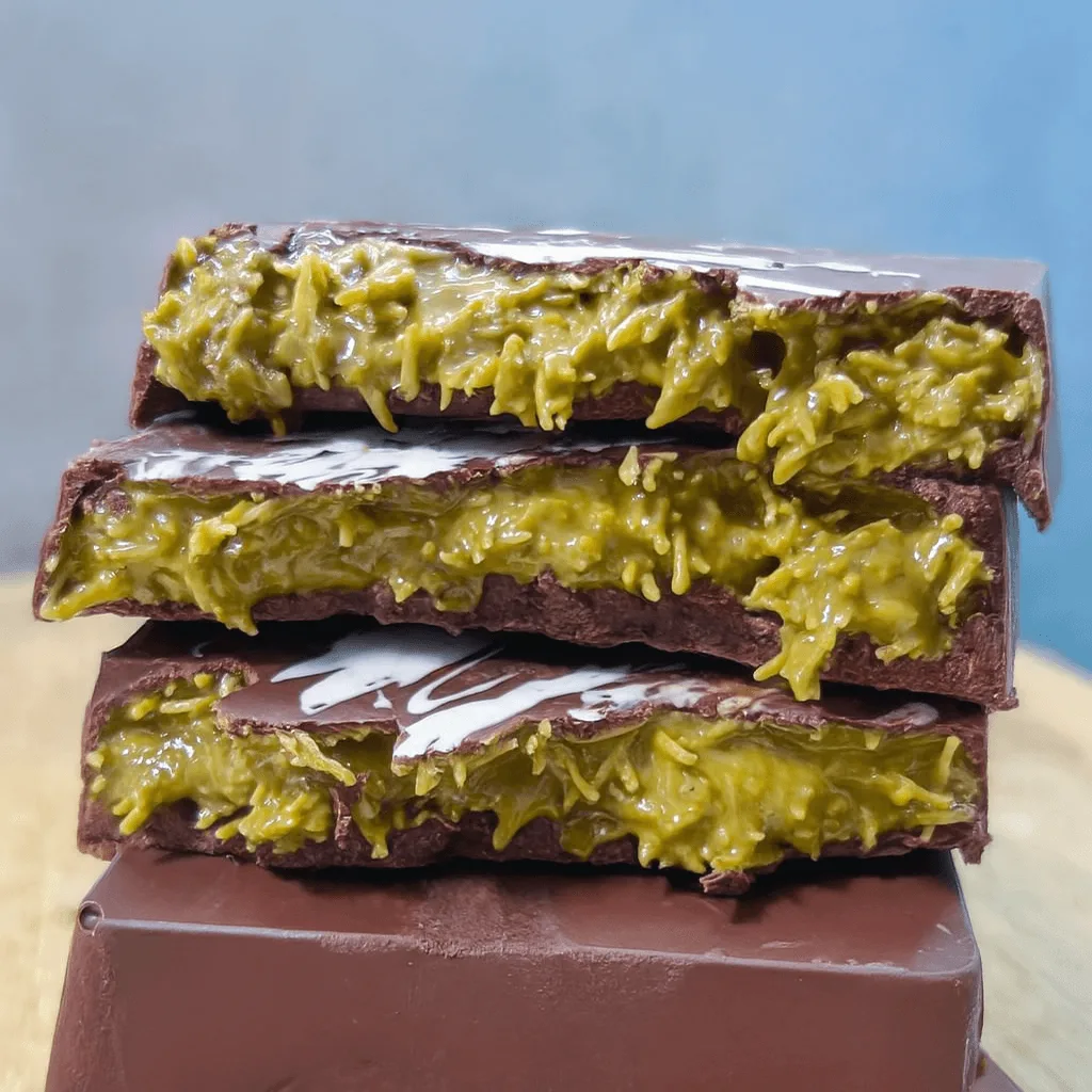 Pistachio chocolate bars stacked on top of each other with gooey green filling